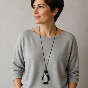 Pinguin-Pulloverkette an einer KI-generierten Frau mit grauem Pullover