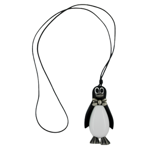 Schwarz-weißer Pinguin-Anhänger mit silbergrauer Fliege und Füßen an einer langen schwarzen Kordel auf weißem Hintergrund.