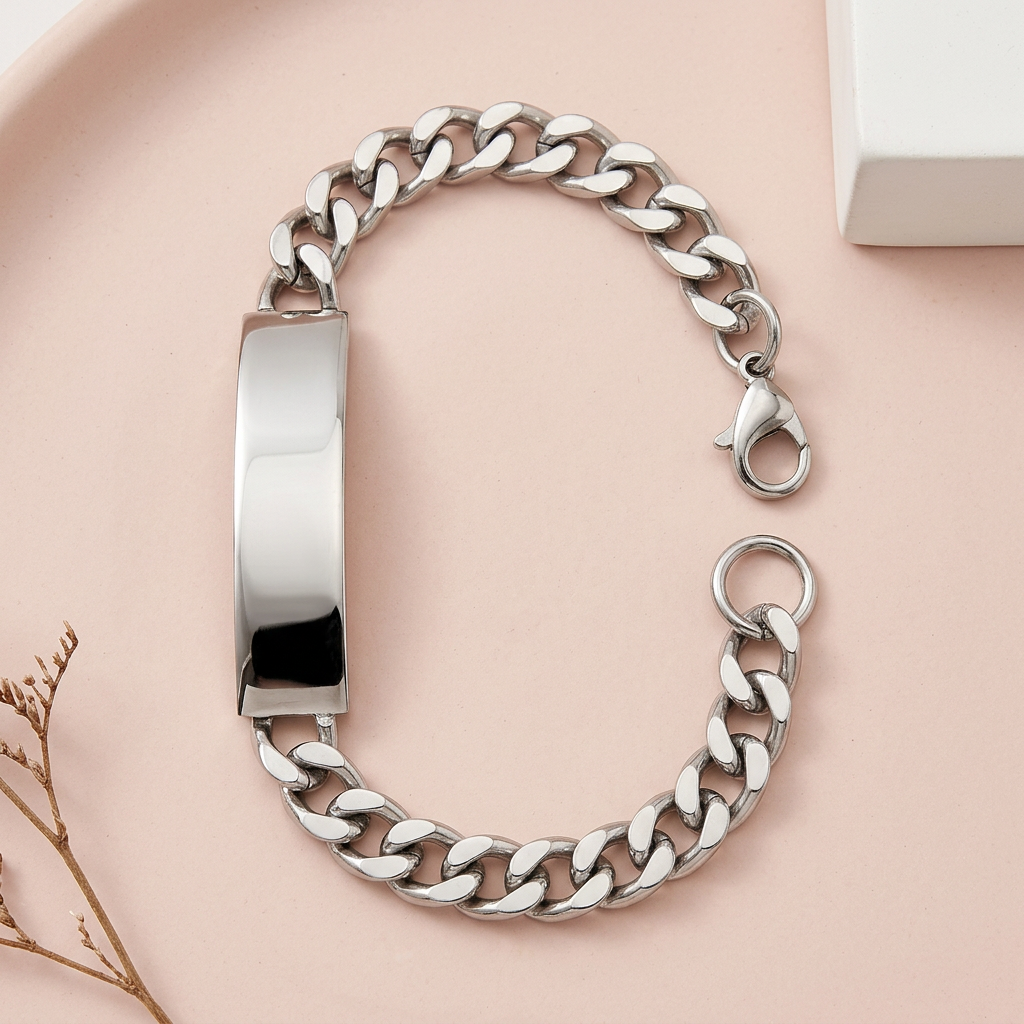 Silberfarbenes Schildband-Armband mit Panzerkette und offenem Karabiner auf roséfarbenem Untergrund mit weißer Keramik und trockenem Zweig.