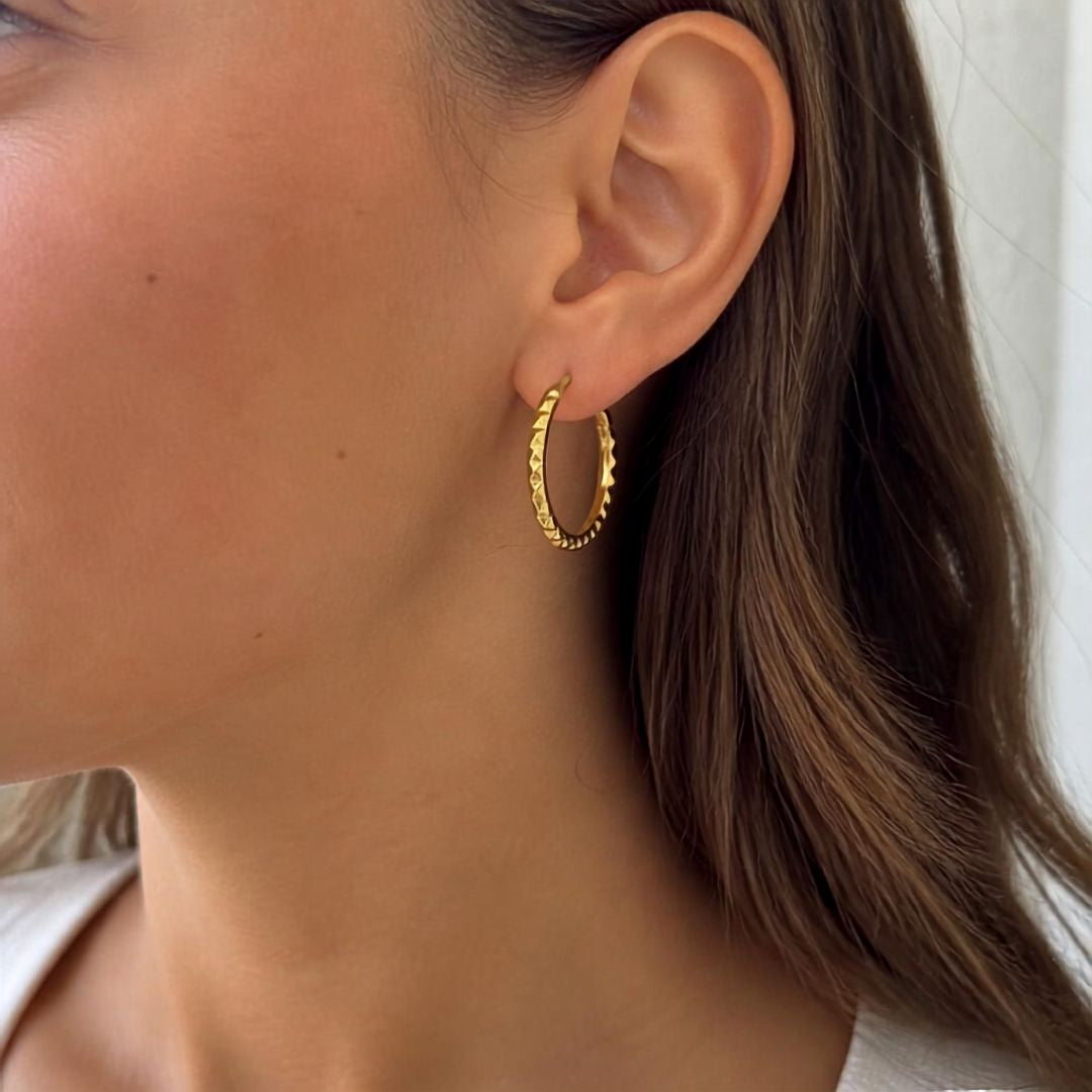 Diamantierte Creole aus 9 Karat Gelbgold am Ohr getragen, 17 × 1 mm