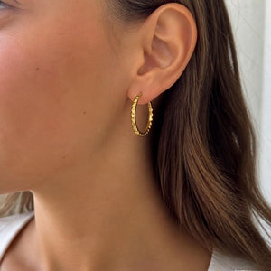 Diamantierte Creole aus 9 Karat Gelbgold am Ohr getragen, 17 × 1 mm