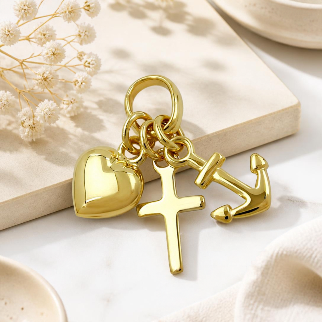 Glaube-Liebe-Hoffnung-Anhänger aus 9 Karat Gold vor dekorativem Hintergrund