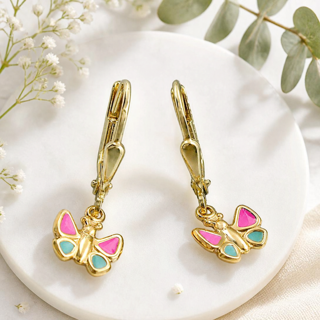Schmetterlings-Ohrhänger aus 9 Karat Gold mit pink-hellblauen Flügeln vor dekorativem Hintergrund