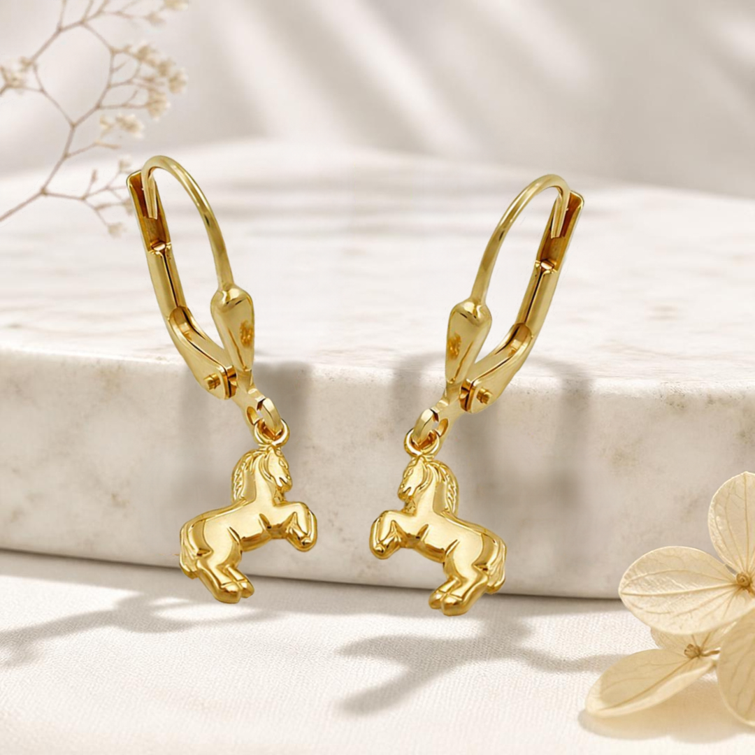 Pferde-Ohrhänger aus 9 Karat Gold an einem hellen Steinpodest mit dezenter Blütendekoration