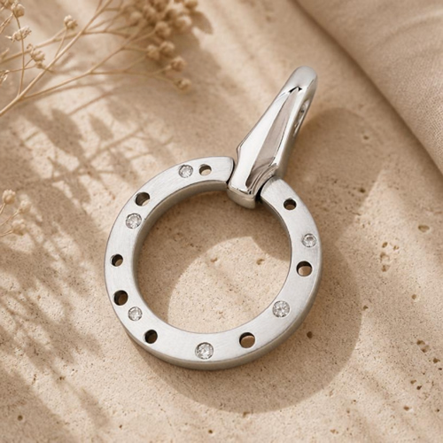 Lochring-Anhänger aus Silber 925 mit weißen Zirkonia auf hellem Stein