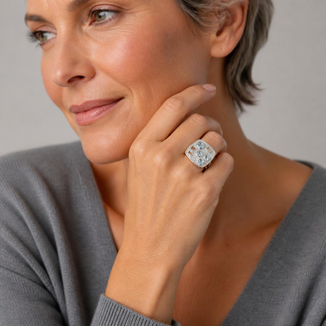 Silberring mit Aqua-Zirkonia und weißen Mikropavé-Zirkonia am Finger einer KI-generierten Frau, Trageansicht