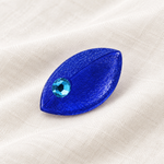 Blaue Maus-Brosche auf hellem Leinen