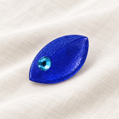 Blaue Maus-Brosche auf hellem Leinen